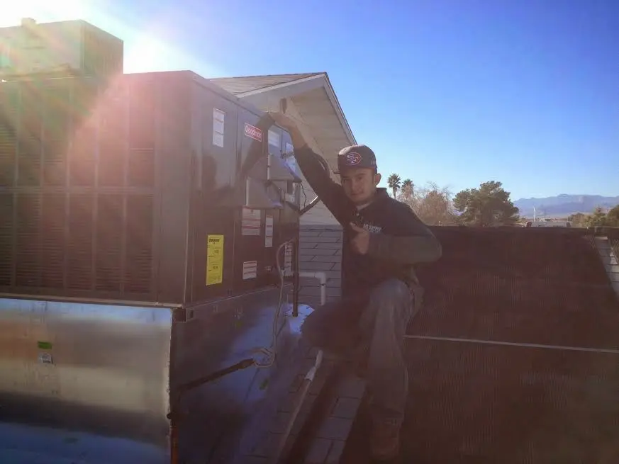HVAC technician performing Heat Pump Repair on a rooftop unit in Boxford